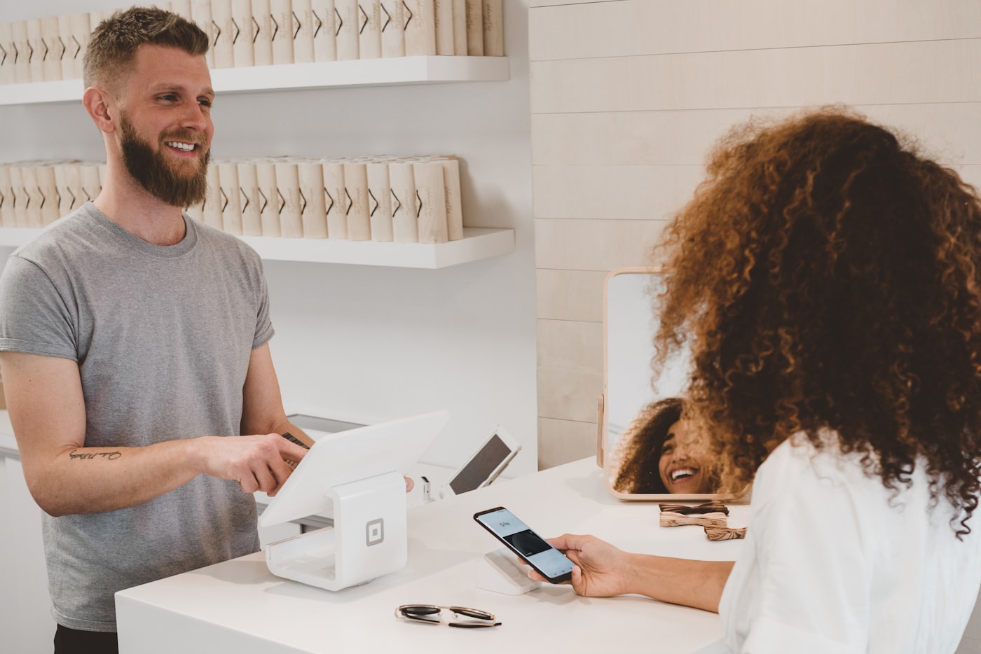 Cashier taking a card payment at a shop counter with a receipt printer